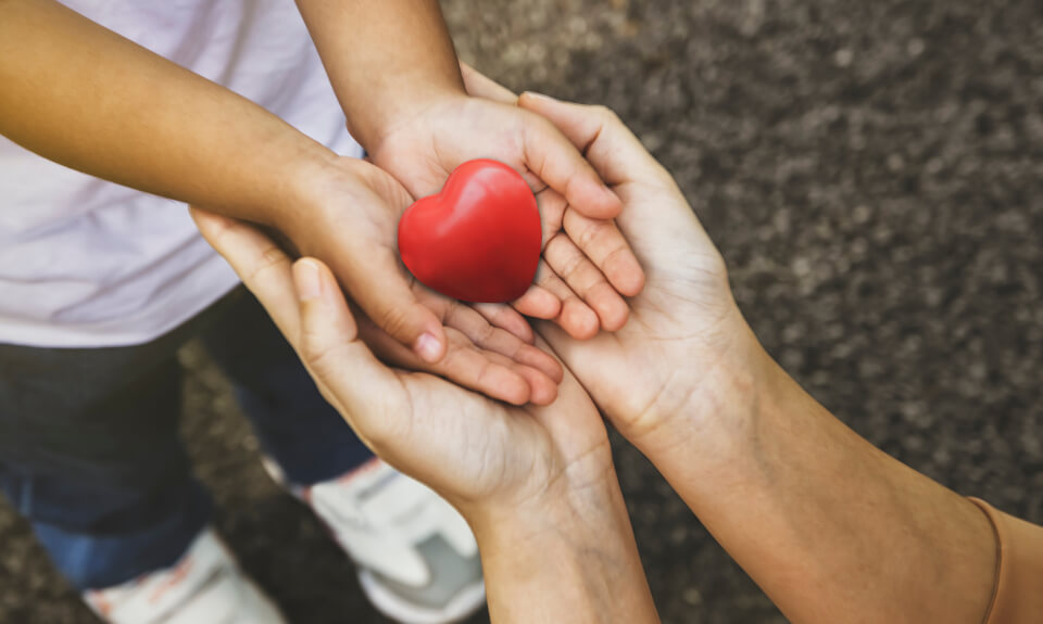 Young girl holding heart shape with both hands